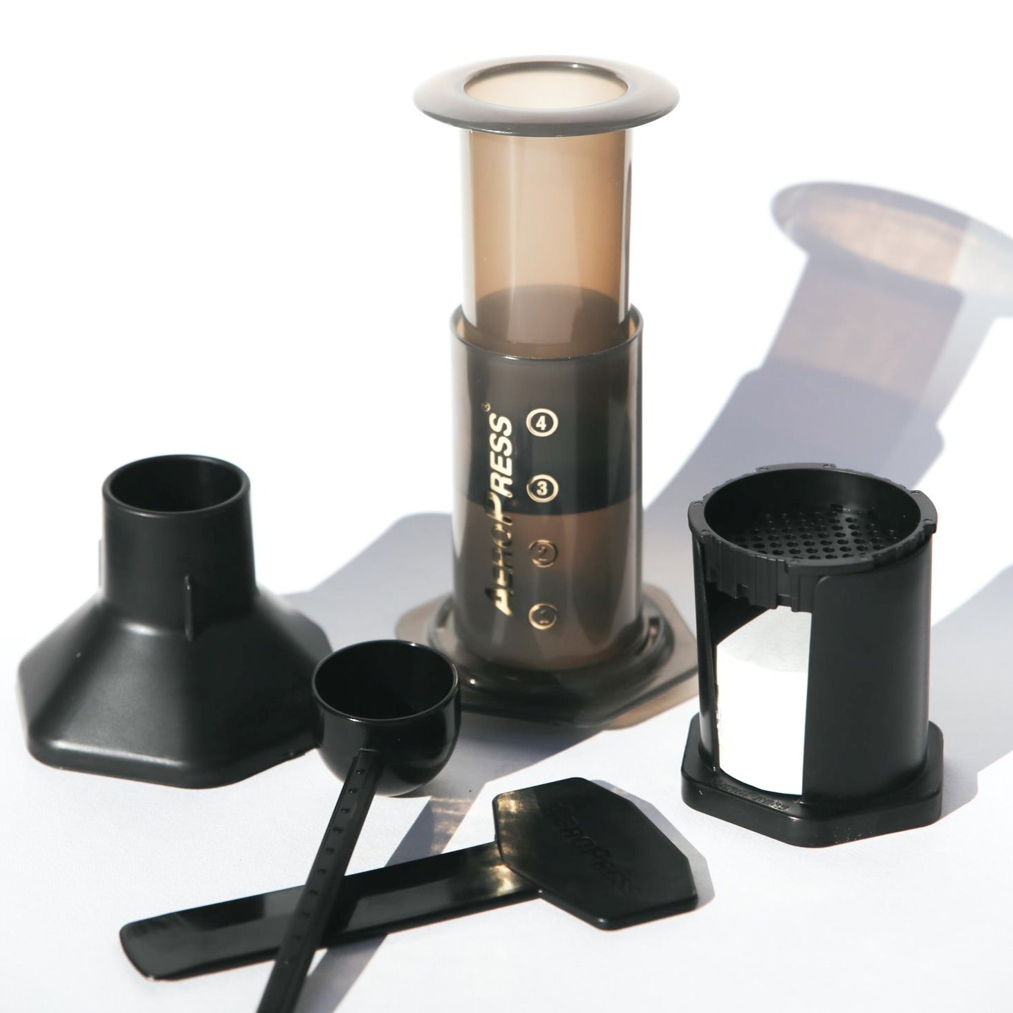 AeroPress coffee maker with individual parts on white